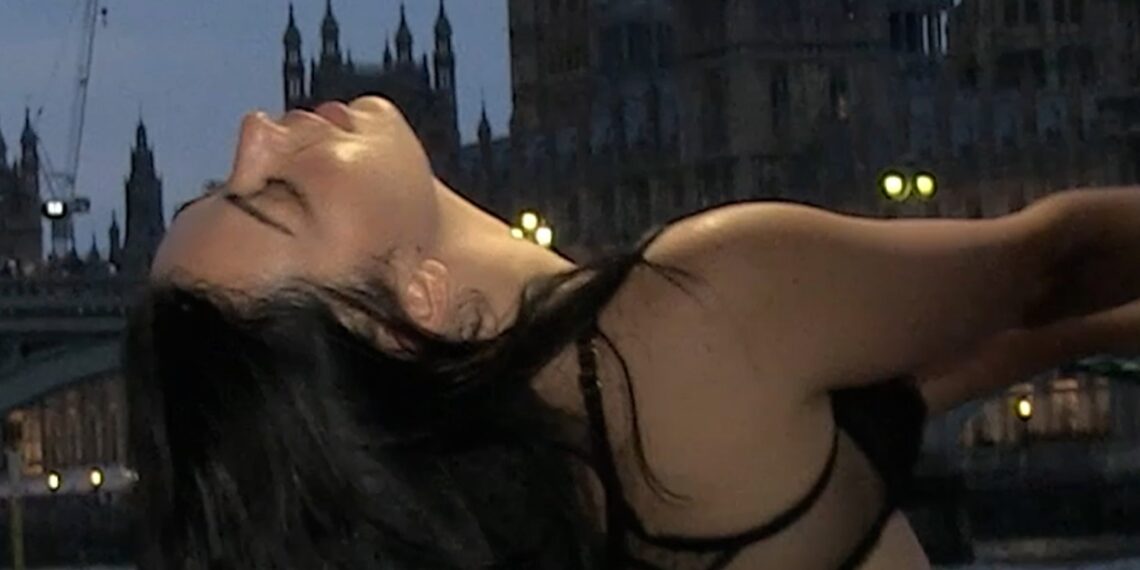 Charli XCX poseert topless op een barge op de Theems.